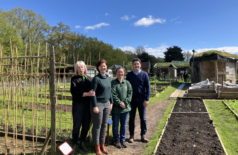 Photo of Huw standing next to flower planting beds with team from Little Gate Farm